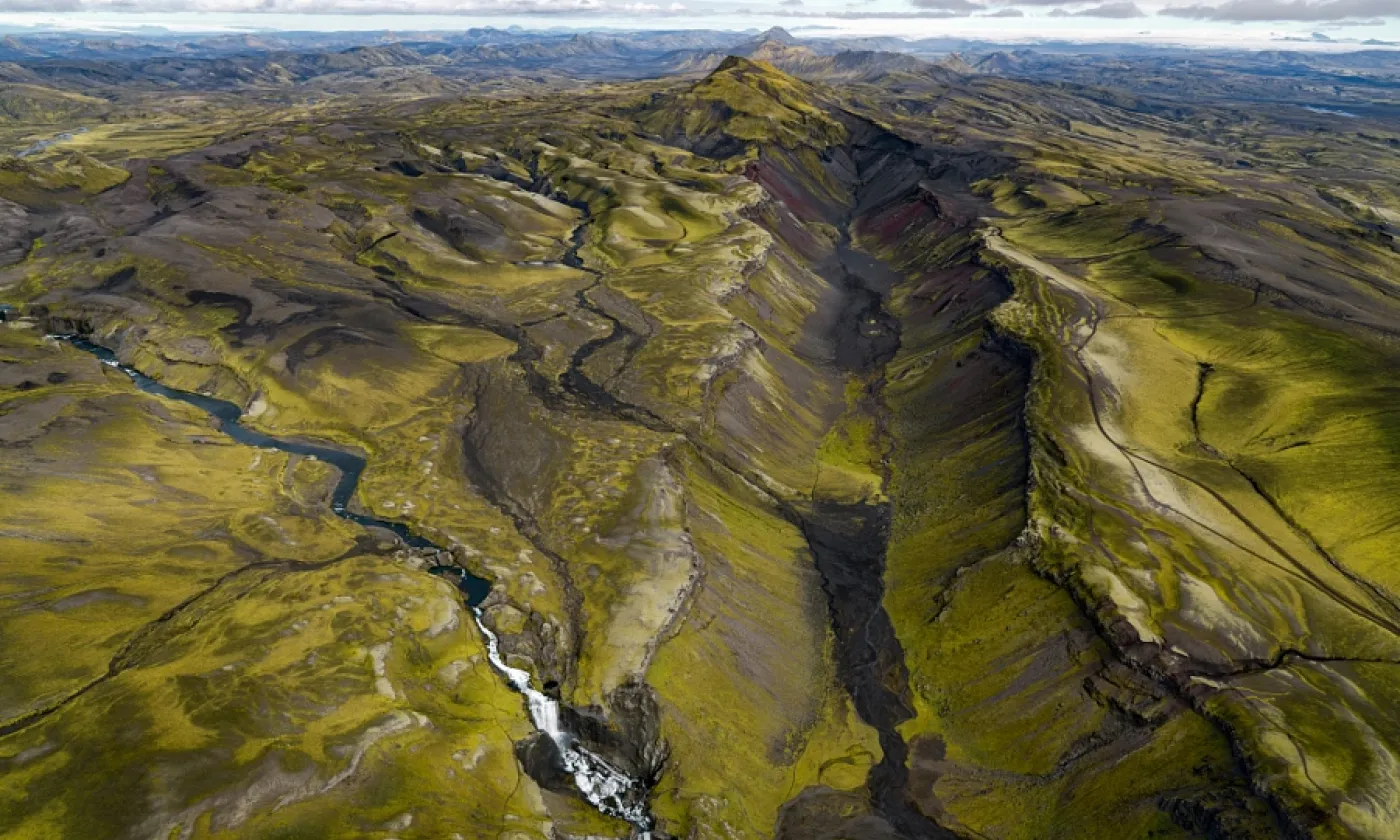 Vue aérienne de l'Eldgjá en direction du nord avec l'Ófærufoss au premier plan et le Vatnajökull à l'horizon © CC Илья Григорик