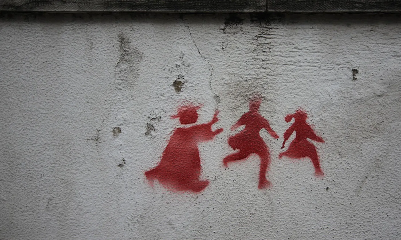 Graffiti sur un mur de Lisbonne montrant un prêtre pourchassant deux enfants. © Wikimedia Commons/Milliped/CC-BY-3.0